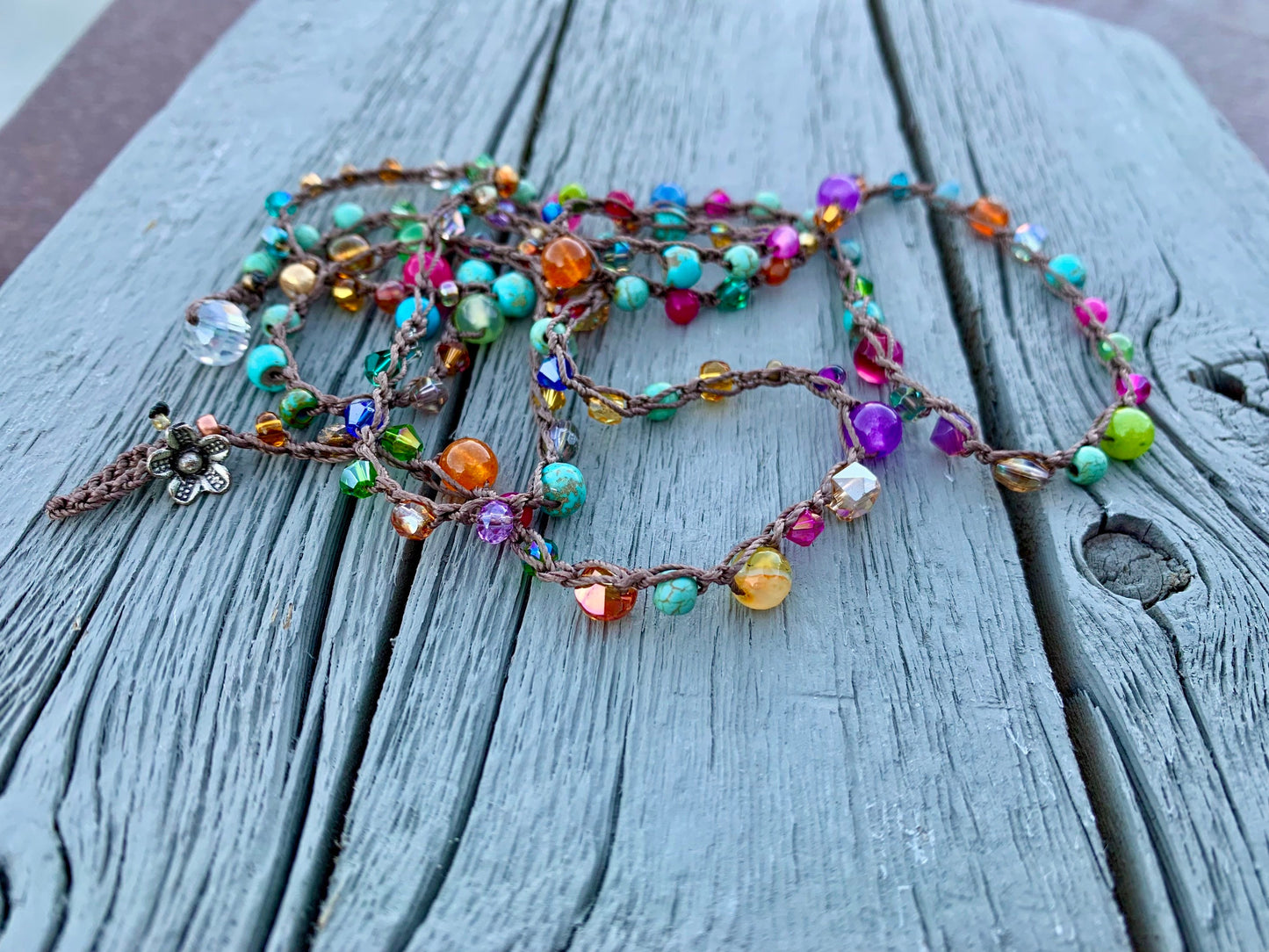 Colorful boho crocheted wrap, with bright turquoise, hot pink, orange gold..